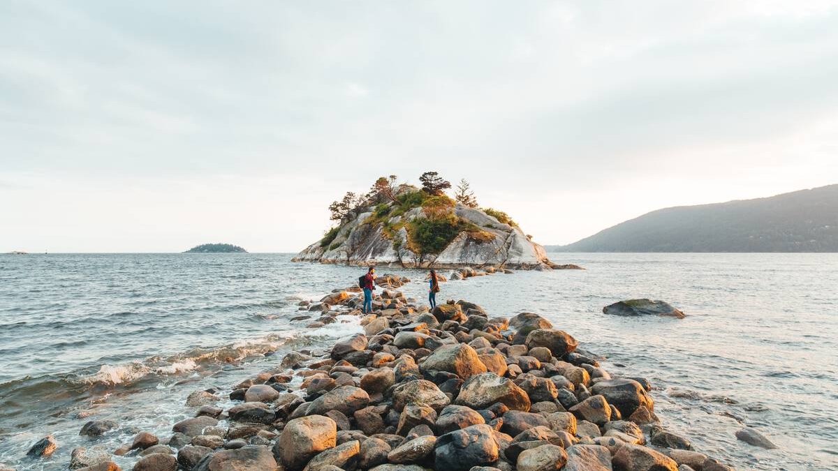 Two people explore the shoreline at Whytecliffe Park in West Vancouver.