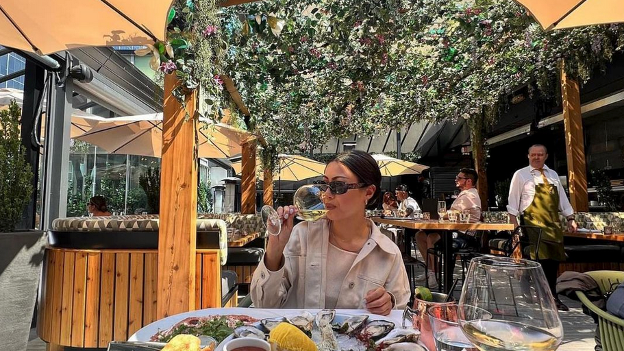 A woman enjoys seafood at The Roof at Black and Blue
